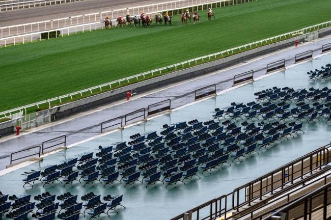 Team Spirit ridden by Tony Piccone heads the field past empty grandstands before going on to win the eighth race at Hong Kong's Sha Tin racecourse on Sunday. — AFP 