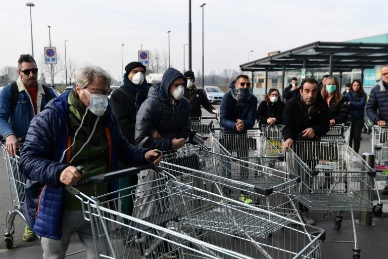 Residents wait to be alowed into a supermarket in groups in the small northern Italian town of Casalpusterlengo as the number of COVID-19 cases mounts. — AFP