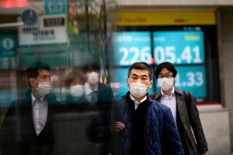 Pedestrians wearing face masks against the spread of the coronavirus spotted on a street in Tokyo. — AFP