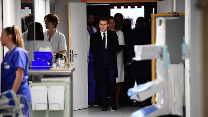 French President Emmanuel Macron (C) visits the Pitie-Salpetriere hospital in Paris on Thursday where the first French victim of COVID-19 passed away the day before. — AFP