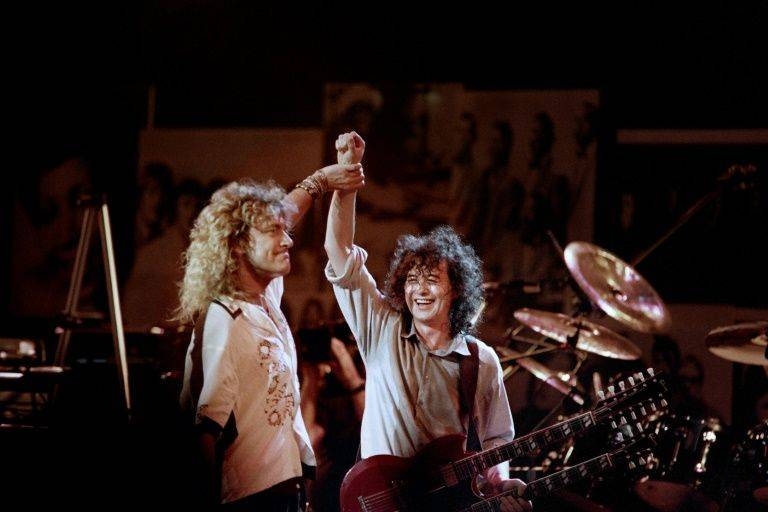 British singer Robert Plant, left, holds hands raised high with British guitarist Jimmy Page during a Led Zeppelin reunion performance at Madison Square Garden in 1988. — AFP 