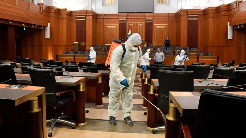 Workers wearing protective gear spray disinfectant the main hall of the Lebanese Parliament in Beirut. -- Courtesy photo
