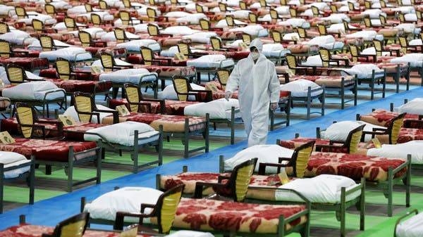 A man in protective clothing walks past rows of beds at a temporary 2,000-bed hospital for COVID-19 coronavirus patients set up by the Iranian army at the international exhibition center in northern Tehran. -- Courtesy photo