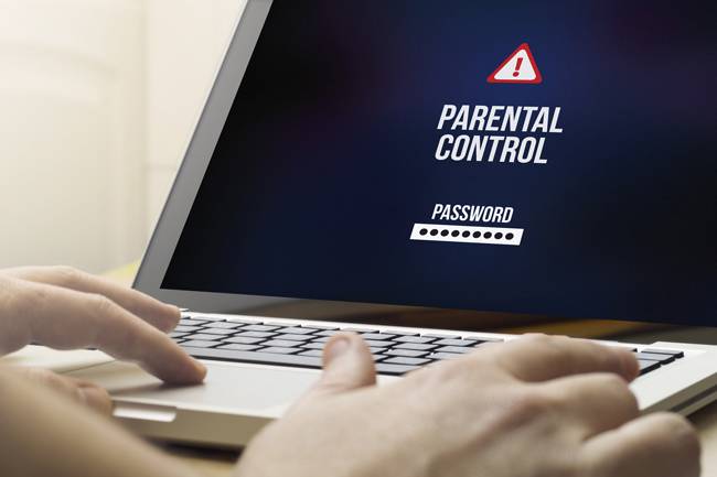 Technology child protection concept: Man using a laptop with parental control on the screen.