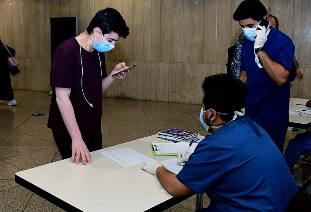 Saudi citizens, who arrived at King Fahd International Airport in Dammam from Kuala Lumpur on Saturday, form a queue before completing the formalities.
