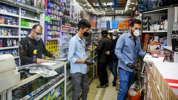 Iranian men, wearing personal protective equipment, are pictured at an electronics shop in Mashhad. -- Courtesy photo
