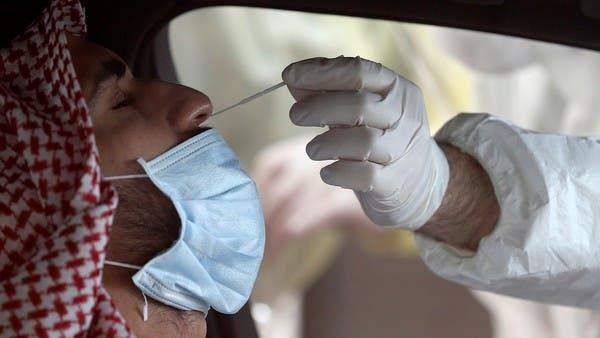 Medical staff wearing protective gloves take a swab from a man during drive-thru coronavirus testing at Bahrain Exhibition Center, in Manama. -- File photo