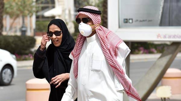 A Saudi man, wearing a protective mask as a precaution against coronavirus, walks with his wife in Riyadh. — File photo