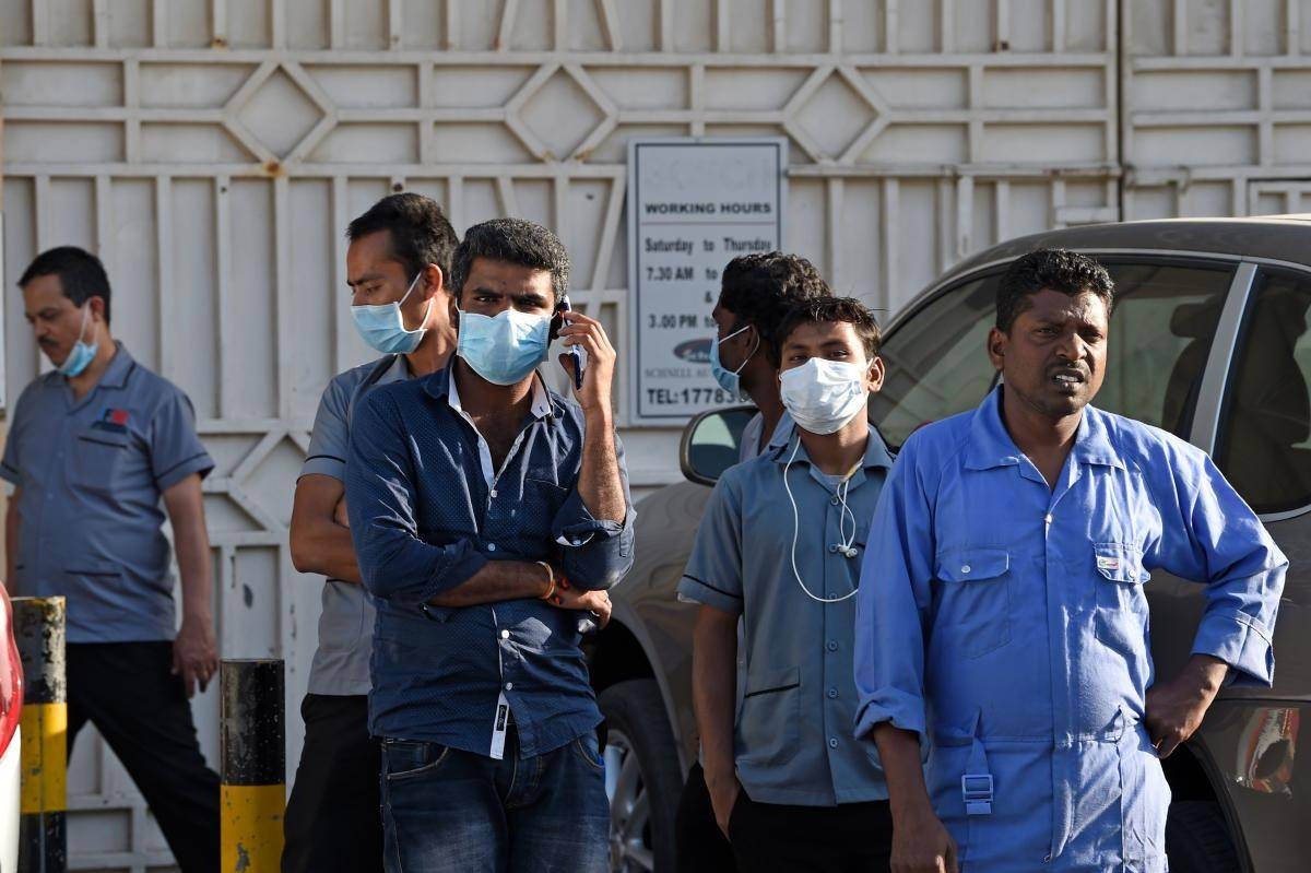 Migrants workers are seen outside a building in the Salmabad industrial area of Bahrain in this file picture. — Courtesy photo