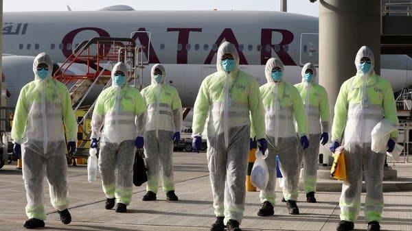 Employees of Qatar Aviation Services walk along the tarmac after sanitizing an aircraft. — Courtesy photo