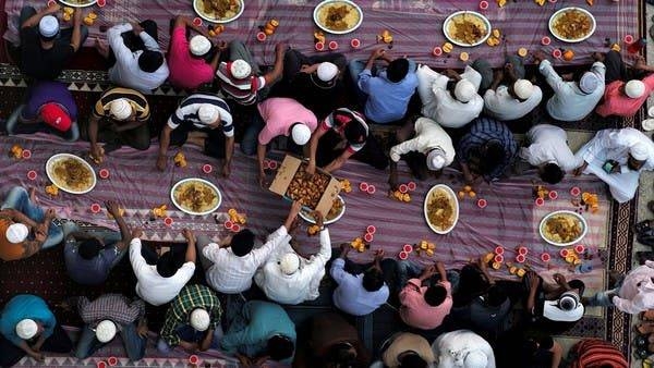 Muslims distribute food as they wait to have their iftar (breaking fast) meals outside a mosque during the holy fasting month of Ramadan, in Manama in this last year's photo
