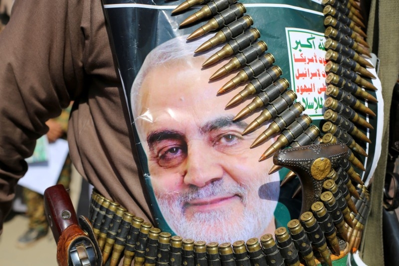 A supporter of the Houthis in Yemen has a poster attached to his waist of Soleimani. 