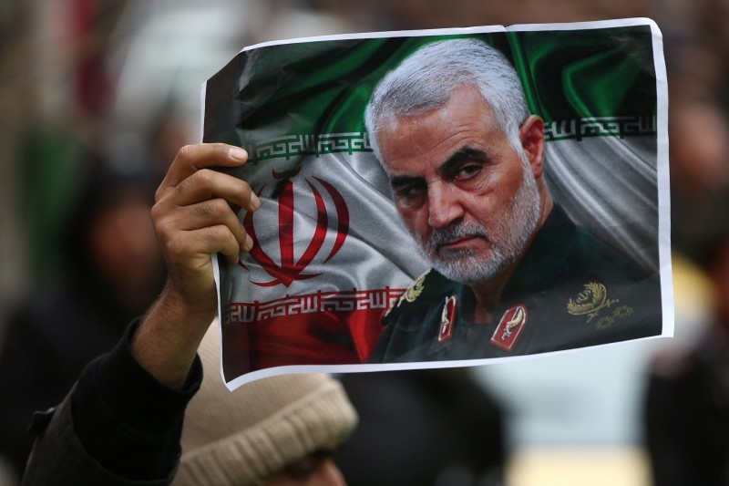 A supporter of the Houthis in Yemen has a poster attached to his waist of Soleimani. 