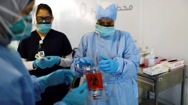 Medical staff wear protective face masks and gloves at a coronavirus screening center in Abu Dhabi. -- File photo
