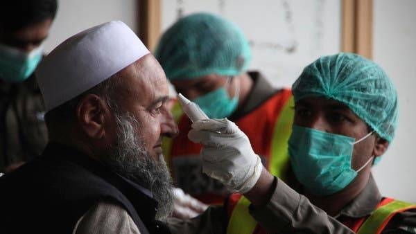 A health official of an emergency rescue service checks the body temperature of a government employee in Peshawar. -- File photo
