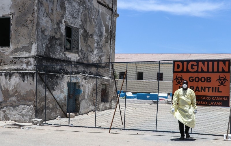 Medical workers in protective suits carry the body of a man who died of COVID-19, before he is buried in Mogadishu, last week. -- Courtesy photos
