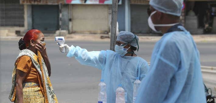 A health worker checks the temperature of a woman during lockdown to prevent the spread of new coronavirus Ahmedabad, in the Indian state of Gujarat. — Courtesy photo