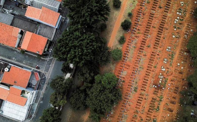 Gravediggers bury a coffin near open graves at Vila Formosa cemetery, Brazil's biggest cemetery, in Sao Paulo. -- Courtesy photo
