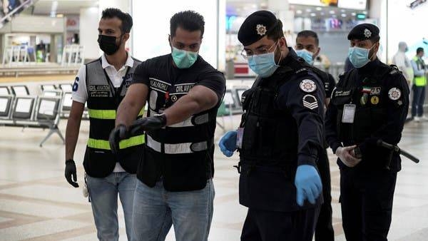 Police and civil aviation personnel wearing protective face masks in Kuwait. -- File photo
