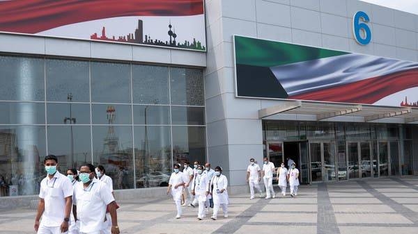 Nurses walk in front of a makeshift coronavirus testing center at the Mishref Fair Grounds in Kuwait City. — File photo
