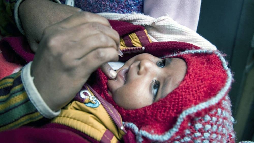 A child receives oral polio vaccine from a house-to-house polio vaccination team in the Kamla Nehru Nagar slum in Patna, in the Indian state of Bihar. Urban slums such as this one are intensively targeted during the polio campaigns. — courtesy Bill & Melinda Gates Foundation/Prashant Panjiar