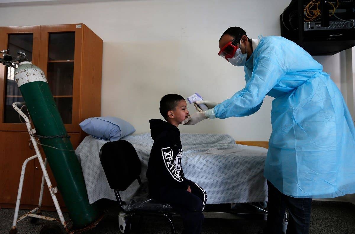 A Palestinian health worker checks the body temperature of a child at a UNRWA school at Al-Shati refugee camp in Gaza City. — Courtesy photo