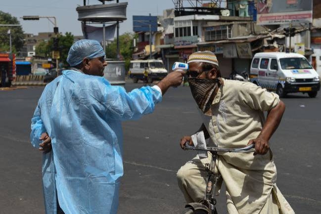 A health worker checks the body temperature of a man during a government-imposed nationwide lockdown as a preventive measure against the COVID-19 coronavirus in the western Indian city of Ahmedabad. — Courtesy photo