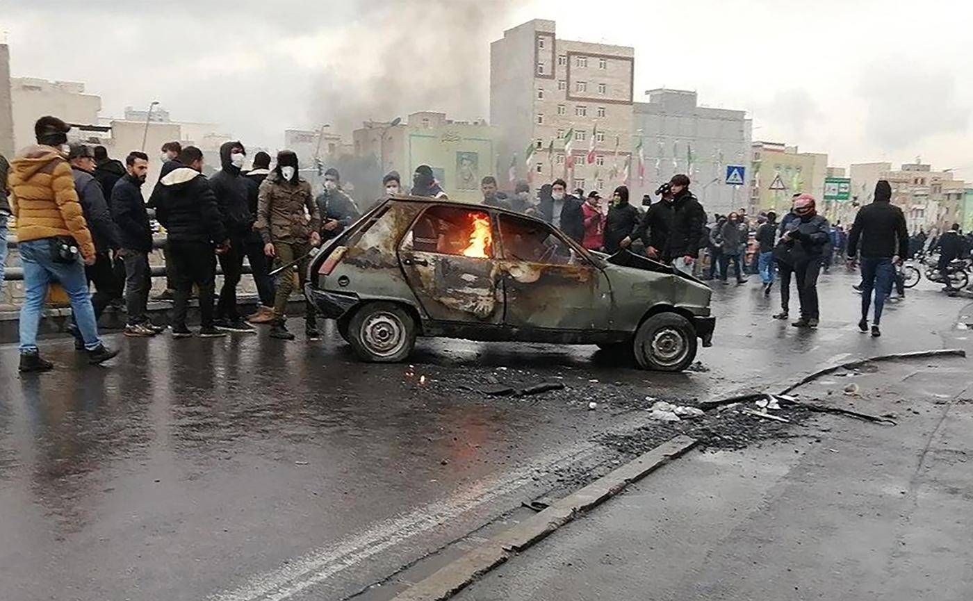 Iranian protesters gather around a burning car during a demonstration against an increase in gasoline prices in Tehran in this November 16, 2019 file photo