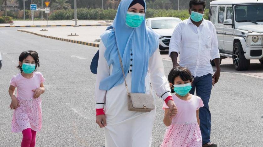 A family wear protective face masks, as they arrive at a makeshift coronavirus testing center at the Mishref Fair Grounds in Kuwait City in this file photo.
