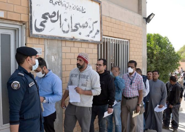 Expatriates queue up for coronavirus clearance certificate at a health clinic in Subhan, Kuwait, in this file photo.
