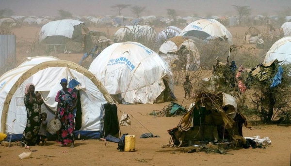Women and children stand outside temporary tents at a refugee camp near the Kenya-Somalia border. — courtesy UNICEF/Kate Holt