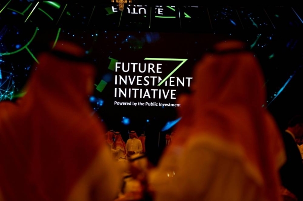 Participants look at a sign of the Future Investment Initiative during the investment conference in Riyadh, Saudi Arabia October 23, 2018. REUTERS/FILE PHOTO