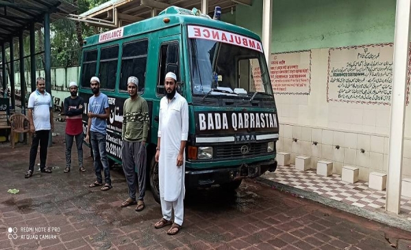 Young Muslim volunteers stand ready near the van used for carrying dead bodies of coronavirus victims. — File photo
