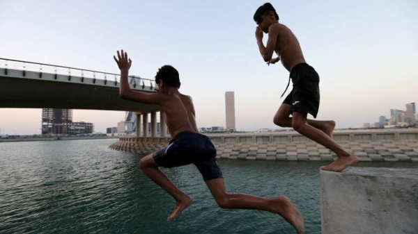 Children jump on the man-made canal at Bahrain Bay to cool themselves from the heat in the Bahraini capital of Manama on June 20, 2019. — Courtesy photo