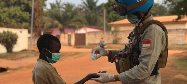 A peackeeper from the UN Multidimensional Integrated Stabilization MIssion in the Central African Republic (MINUSCA) sanitizes a little boy's hands. — Courtesy photo