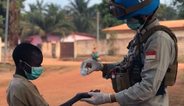 A peacekeeper from the UN Multidimensional Integrated Stabilization Mission in the Central African Republic (MINUSCA) pours hand sanitizer into a child’s hand. — courtesy MINUSCA