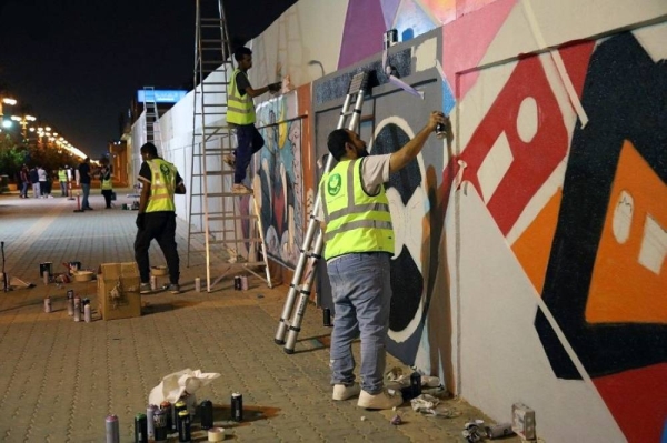 File photo shows volunteers removing graffiti from public places during a campaign launched by the municipality to beautify Riyadh.