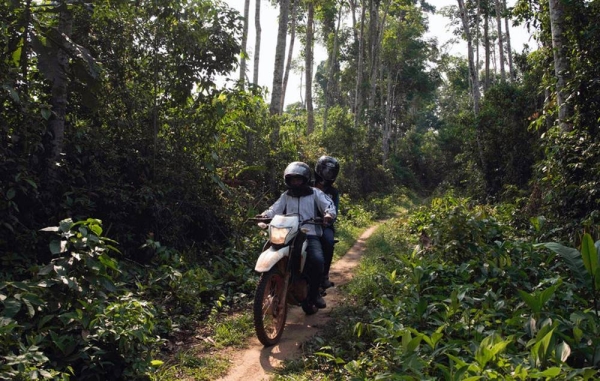 Marie-Roseline Darnycka Bélizaire, an epidemiologist with the World Health Organization, rides through the forest near Itipo on the way to a follow-up visit with a contact. — courtesy WHO/Lindsay Mackenzie