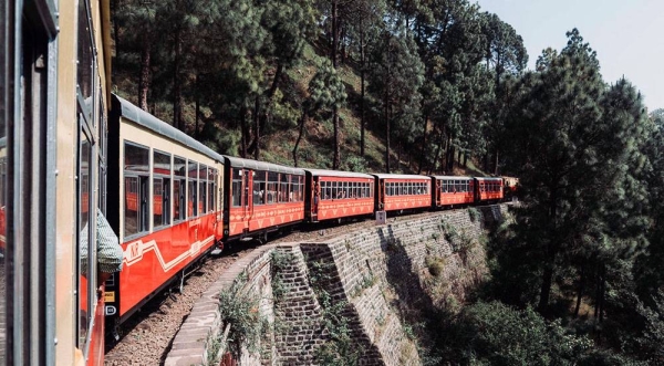 Passengers look out of the window as a train pulls into a railway station in Delhi, India. — courtesy Unsplash/Killian Pham