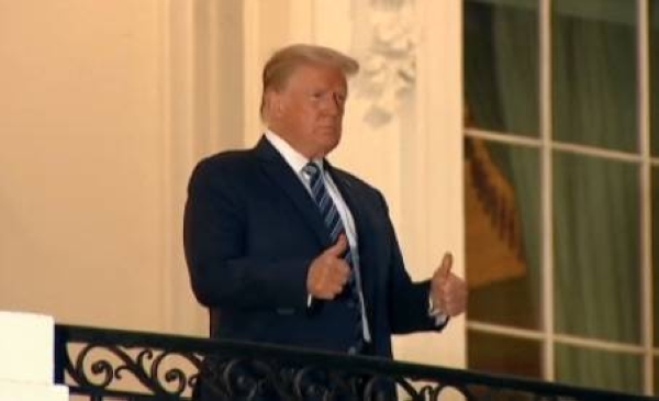 A video grab of US President Donald Trump on his return to the White House. He is caught standing on a flag-decked Truman Balcony for a photo op.