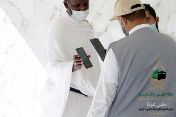 A pilgrim shows his permit to a security personnel prior to performing Umrah at the Grand Mosque.