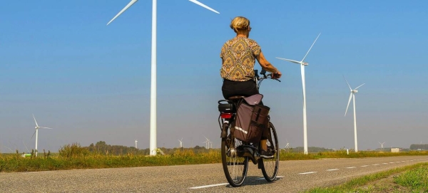 A woman cycles past wind turbines on a country road in Heijningen, the Netherlands, in this file picture. — Courtesy photo