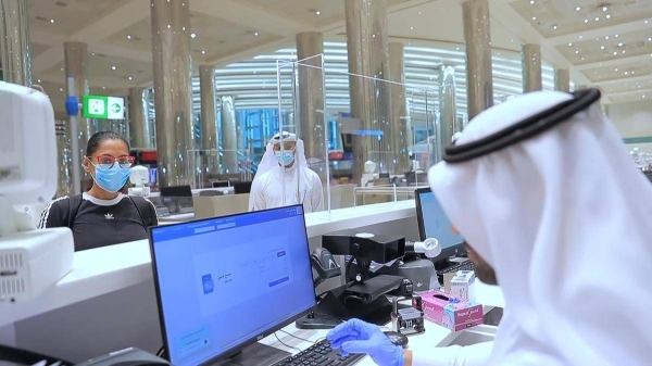 An immigration official checks the documents of a passenger at Dubai International Airport in this file photo. — Courtesy photo