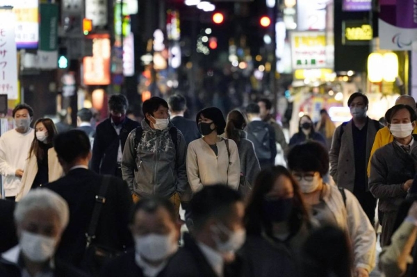 People wearing face masks walk in Tokyo's Shimbashi area amid the unabated rise in coronavirus infections in the capital. — courtesy Kyodo