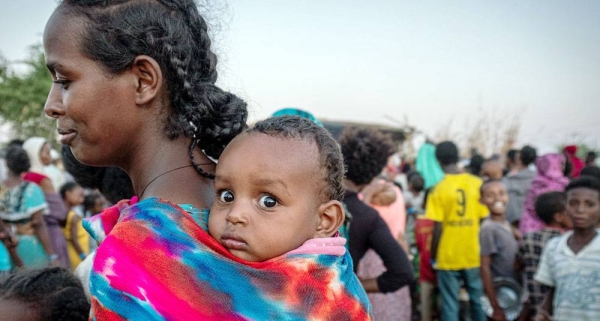 A refugee from Tigray waits in line with her baby to receive food in the Um Rakuba refugee settlement in Sudan. — courtesy WFP/Arete/Joost Bastmeijer