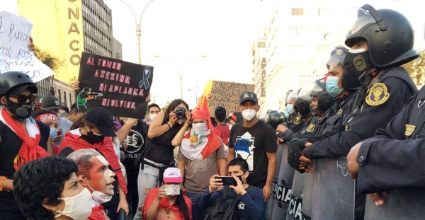 A group of protesters kneeling in front of police officers during demonstrations in Lima, Peru, in November 2020. — courtesy Patricio Lagos Bustamante / LaMula.pe