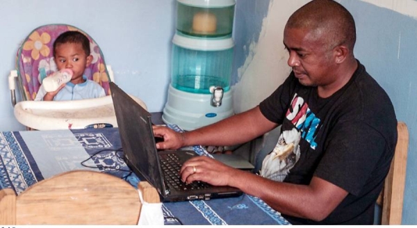 A father takes care of his young child while working from home in Madagascar. — courtesy World Bank/Henitsoa Rafalia