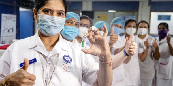 Health workers pose with a vial of COVID-19 vaccine after receiving their shots at a hospital in India. — courtesy UNICEF/Vinay Panjwani