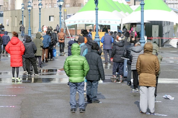 Citizens line up in front of a temporary screening center at Seoul Station Plaza on Thursday. — courtesy Yonhap