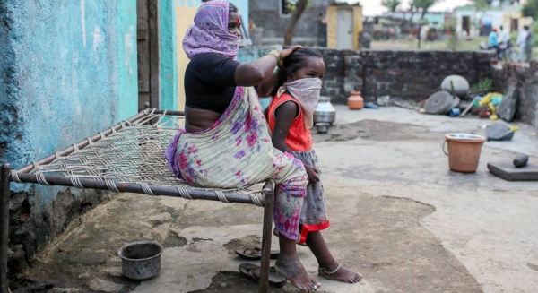 A woman combs her granddaughter's hair outside their home in Maharashtra, India. — courtesy UNICEF/Dhiraj Singh